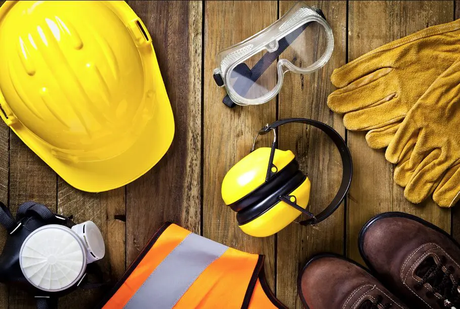 Construction safety equipment on wood background.