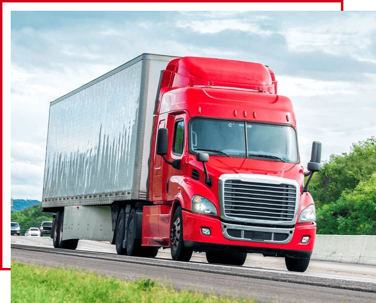 A red truck is driving down the road