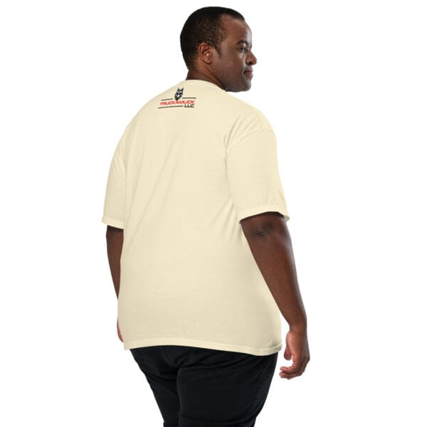 Man wearing a cream t-shirt with a logo.