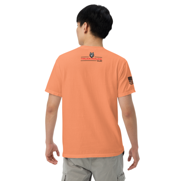 Man wearing an orange t-shirt with a wolf logo.