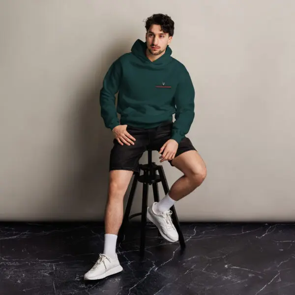 Man in green hoodie sitting on a stool.