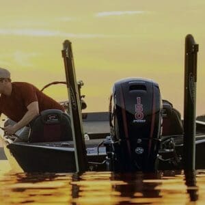 Man fishing from a boat at sunset.