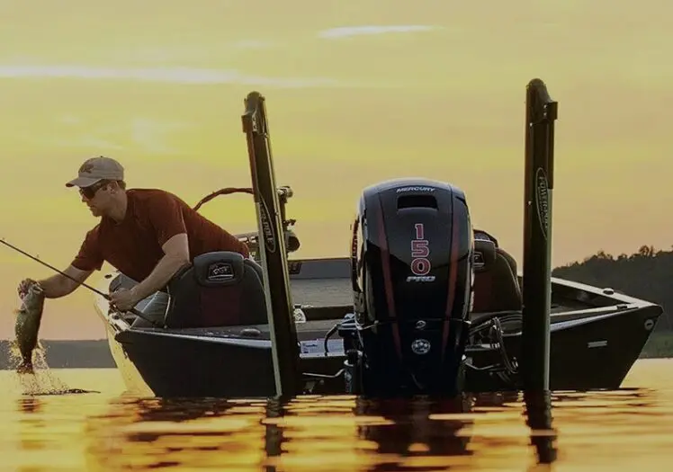 Man fishing from a boat at sunset.