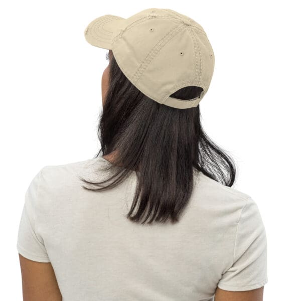 Woman wearing a beige baseball cap.